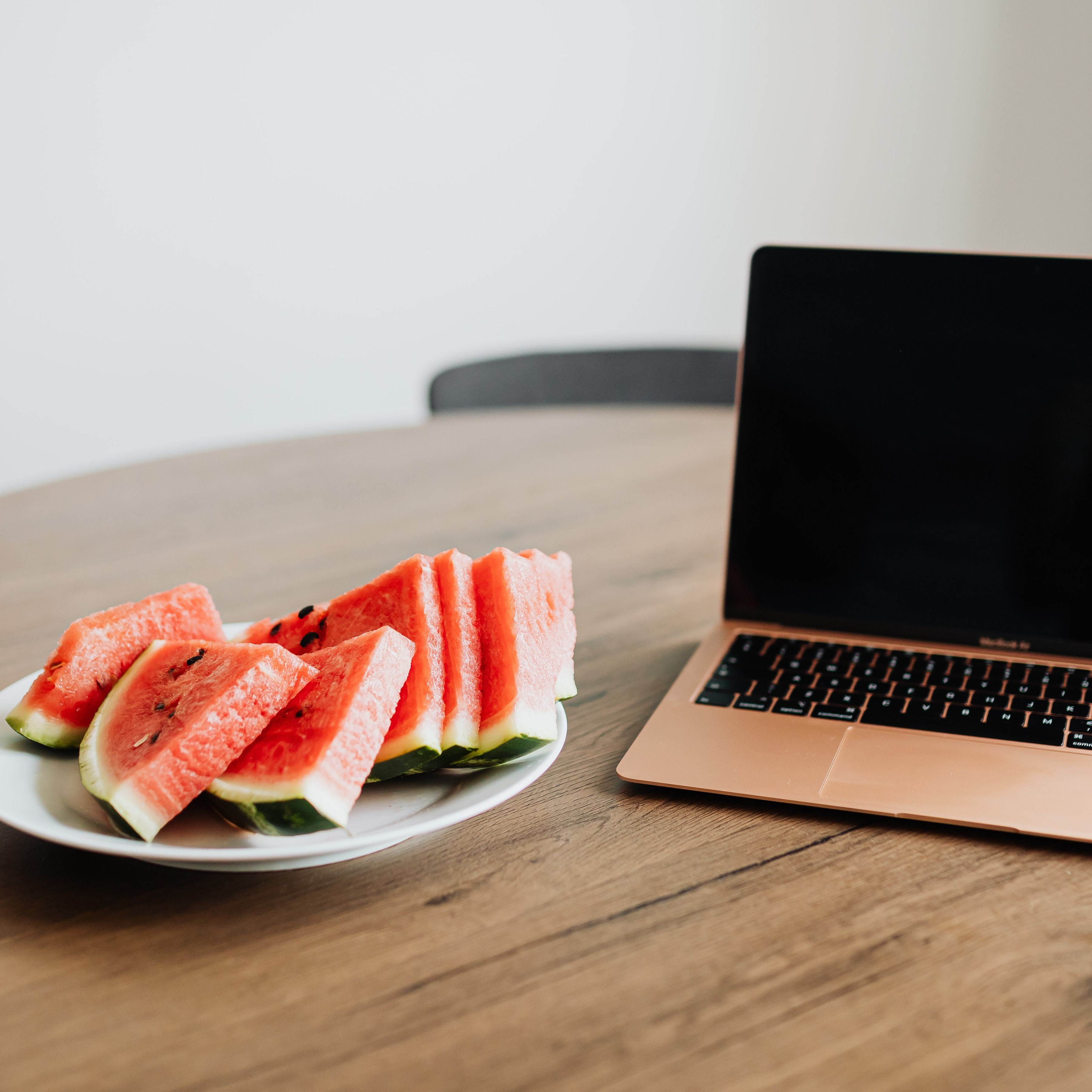 Computador, mesa e frutas